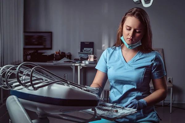 Bir diş kliniğinde onun işyerinde bir sandalyede oturan kadın diş hekimi. — Stok fotoğraf