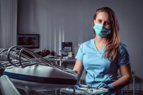 Dentista mulher sentada em uma cadeira em seu local de trabalho em uma clínica odontológica . — Fotografia de Stock