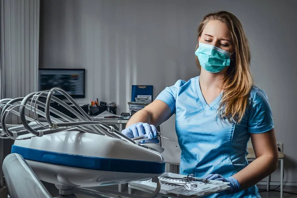 Dentista mulher sentada em uma cadeira em seu local de trabalho em uma clínica odontológica . — Fotografia de Stock