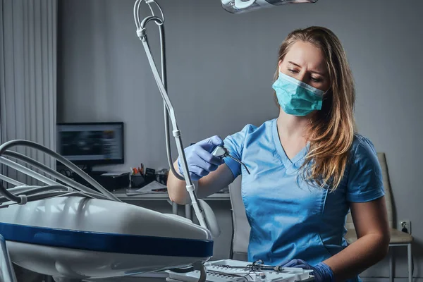 Dentista mulher sentada em uma cadeira em seu local de trabalho em uma clínica odontológica . — Fotografia de Stock