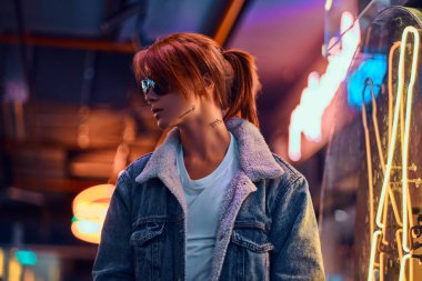 Şık Kızıl saçlı kız sokakta gece ayakta.