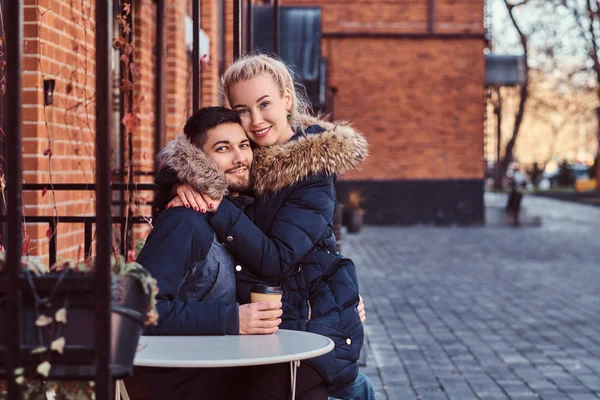 Menina bonita sentado em seus namorados colo no café fora . — Fotografia de Stock