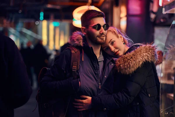 Atractiva pareja enamorada. Una hermosa chica abrazando a su novio de pie en la noche en la calle . —  Fotos de Stock