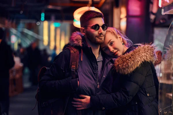사랑에 매력적인 커플입니다. 거리에 밤에 서 있는 그녀의 남자 친구를 포옹 하는 아름 다운 소녀. — 스톡 사진