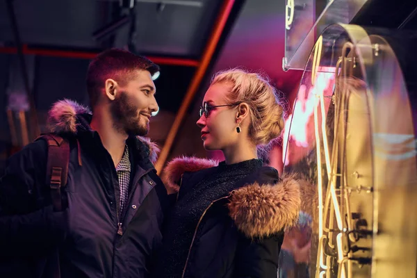 Uma menina bonita e belo homem de pé na noite na rua . — Fotografia de Stock