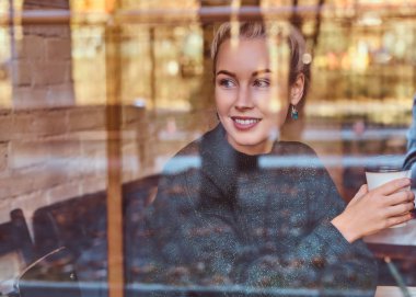 Güzel bir gülümseyen kız kafede kahve içme