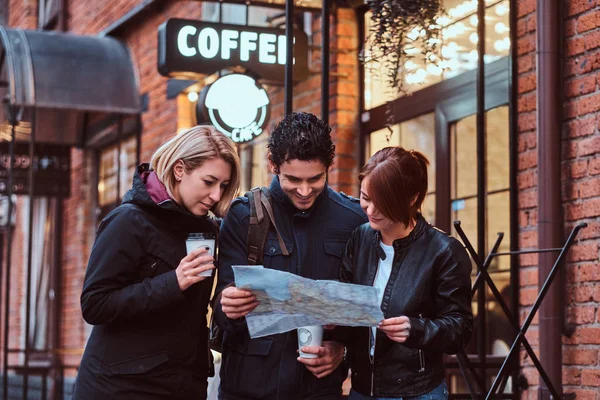 Group of tourists searching place on the map — Stock Photo, Image