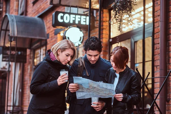 Group of tourists searching place on the map