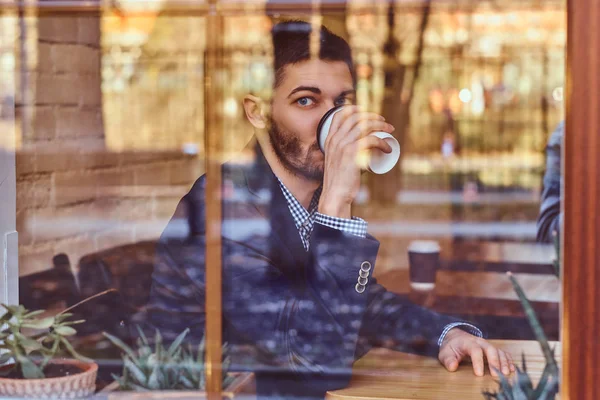 Ένας όμορφος νεαρός άνδρας κομψό, πίνοντας τον καφέ στην καφετέρια. — Φωτογραφία Αρχείου
