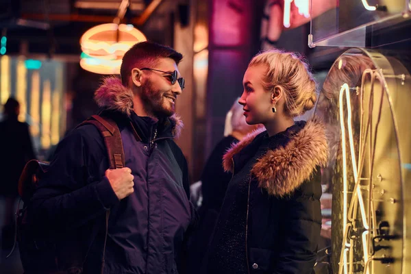 Una hermosa chica y un hombre guapo de pie en la noche en la calle . — Foto de Stock