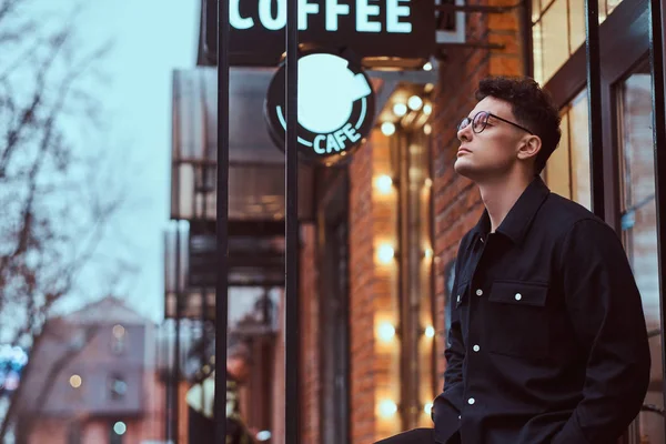 Egy jóképű fiatalember közelében egy kávézó a szabadban. — Stock Fotó