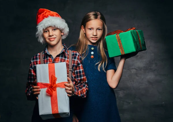 Mutlu küçük çift sarılma ve hediye kutuları Noel zamanda holding. — Stok fotoğraf