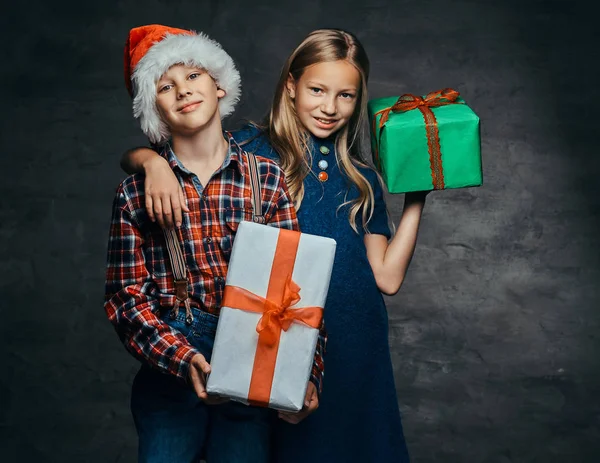 Felice coppia che abbraccia e tiene scatole regalo nel periodo natalizio . — Foto Stock