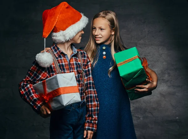 Mutlu küçük çift sarılma ve hediye kutuları Noel zamanda holding. — Stok fotoğraf