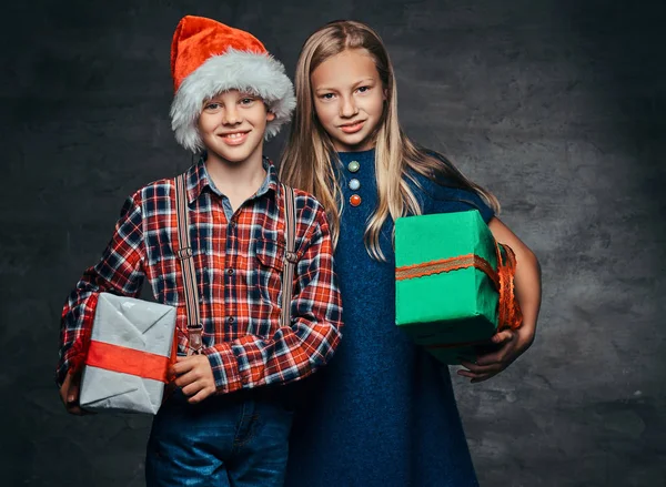 Happy little couple hugging and holding gifts boxes at christmas time. — Stock Photo, Image