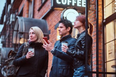 Üç arkadaş öğrenci ile kahve molası dışında bir kafe yakın:.