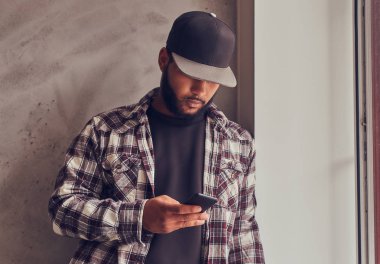 Afrikalı-Amerikalı adam gelecek gri dokulu duvar ayakta iken sosyal ağ sohbet sakallı.