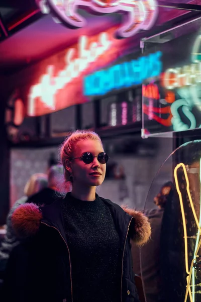 Una chica sensual de pie en la noche en la calle. Letreros iluminados, neón, luces . —  Fotos de Stock