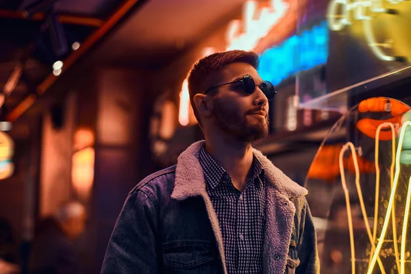 Portrait of a handsome man standing in the night on the street. Illuminated signboards, neon, lights. — Stock Photo, Image