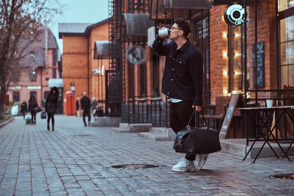 Egy jóképű fiatalember iszik egy kávét, rövid idő gyaloglás legyőz a utca. — Stock Fotó