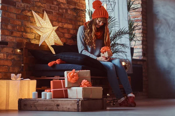 Redhead girl holding a gift box in a decorated living room at Christmas time. — Stock Photo, Image