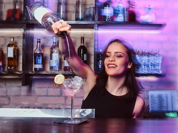 Une belle fille barman prépare un cocktail alcoolisé avec de la vodka — Photo