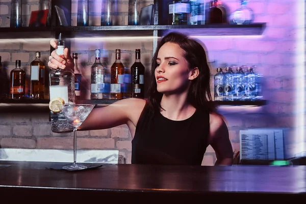 Une belle fille barman prépare un cocktail alcoolisé avec de la vodka — Photo