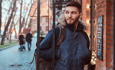 Yakışıklı bir genç adam dışında bir kafe yakın duran.