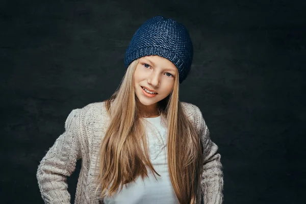 Πορτρέτο του ένα χαμογελαστό κορίτσι με ξανθά μαλλιά, φορώντας ένα καπέλο χειμώνα και πουλόβερ — Φωτογραφία Αρχείου