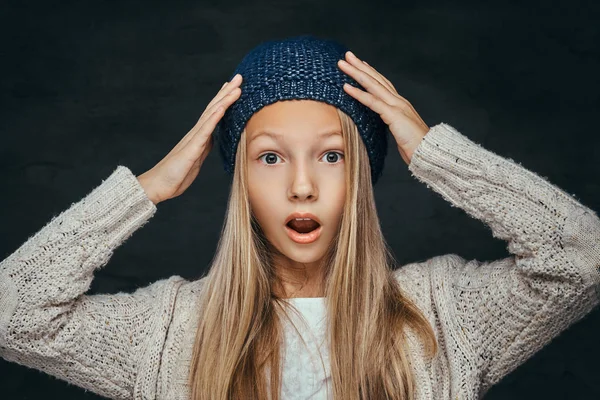 Retrato de una adolescente sorprendida con el pelo rubio usando un sombrero de invierno y suéter —  Fotos de Stock