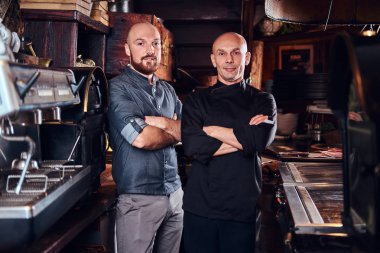 Bir Restoran mutfağında Şef asistanı kollarını bir kamera için poz ile geçti.