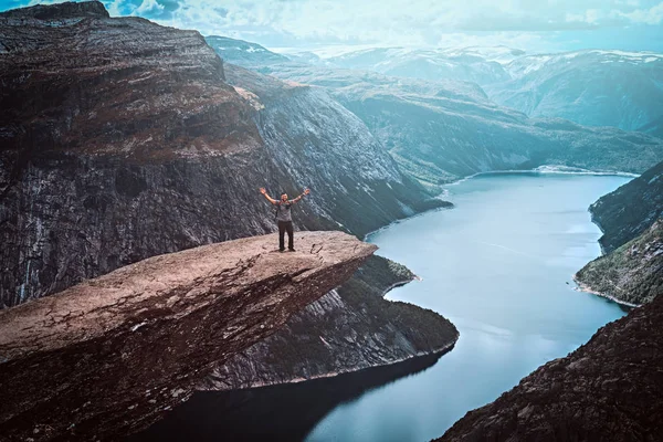 Turista de pie en la Trolltunga y disfruta de una hermosa vista del fiordo noruego . —  Fotos de Stock