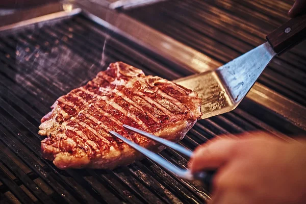 Immagine ravvicinata di una deliziosa bistecca di carne da cucina su una griglia — Foto Stock