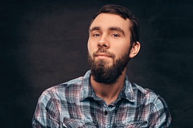 Kareli gömlek giyen sakallı bir adam.