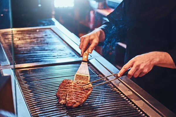 Foto recortada de un chef cocinando delicioso bistec de res —  Fotos de Stock