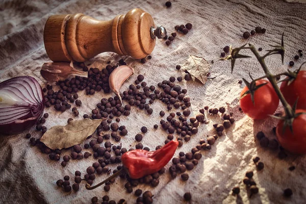 Nahaufnahme der Früchte von schwarzem Pfeffer, rotem Pfeffer, Kirschtomaten und Knoblauch auf Leinenstoff — Stockfoto