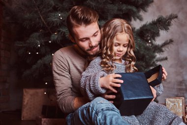 Aşk, Aile, babalık, Noel. Mutluluk baba ve sevimli küçük kızı yere otururken hediyeler açmak