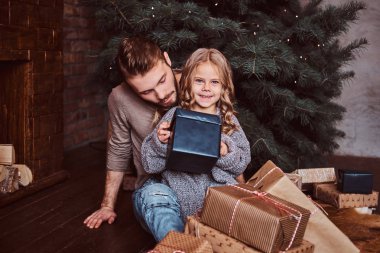 Aşk, Aile, babalık, Noel. Mutluluk baba ve sevimli küçük kızı yere otururken hediyeler açmak