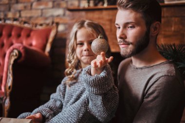Mutluluk sevimli küçük kız babasıyla bir katta evde otururken Noel top tutan
