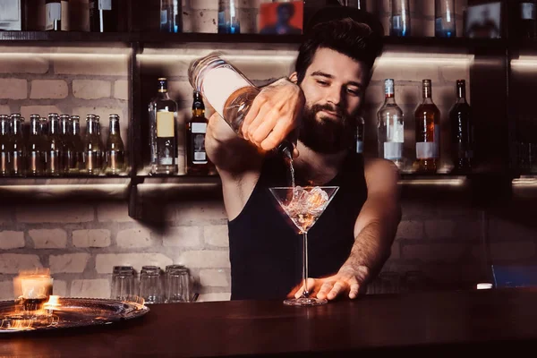 Un barman travaillant derrière le comptoir du bar — Photo