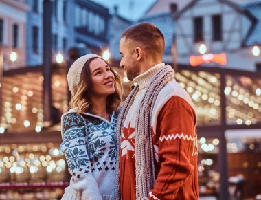 Elele ve birlikte vakit zevk ayakta sokakta Noel zamanda birbirine bakarak Genç bir romantik çift.