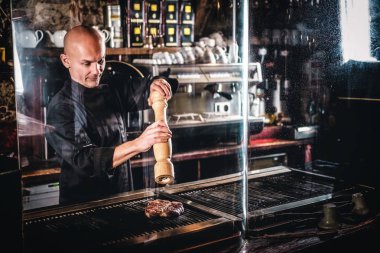 Usta bir mutfak bir restoranda üzerinde tek tip pişirme lezzetli sığır eti biftek giyiyor