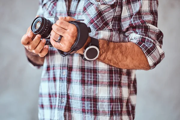 Μερική άποψη του ένας άνδρας φορώντας ένα καρό πουκάμισο, κρατώντας μια φωτογραφική μηχανή. — Φωτογραφία Αρχείου