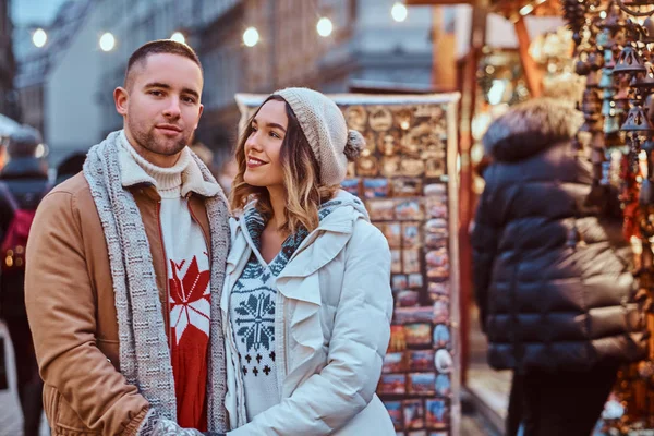 Una pareja romántica feliz tomados de la mano mientras están de pie en la calle en Navidad, disfrutando pasar tiempo juntos . — Foto de Stock