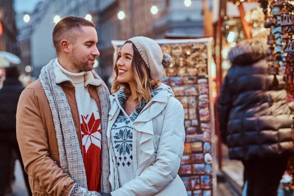 Счастливая романтическая пара, держащаяся за руки, стоя на улице в Рождество, наслаждаясь проведением времени вместе . — стоковое фото
