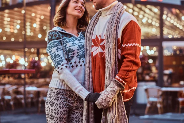 Imagen recortada de una pareja romántica cogida de la mano mientras están de pie en la calle en Navidad, disfrutando pasar tiempo juntos . — Foto de Stock