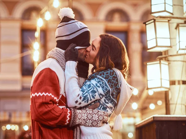 Joven pareja romántica divirtiéndose y disfrutando pasar tiempo juntos en Navidad en la calle decorada con hermosas luces . — Foto de Stock