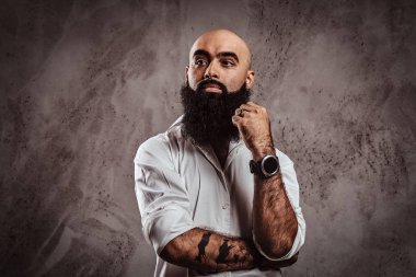 Dalgın bir portresi Arap erkek beyaz bir gömlek giymiş uzağa arıyorsunuz sakallı.