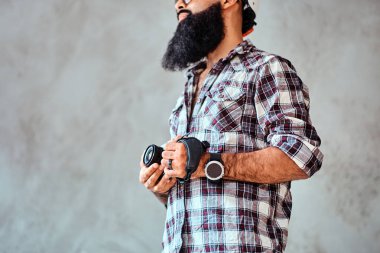 Sakallı bir erkek bir kamera tutarak bir kareli gömlek giyen kırpılmış görüntü.