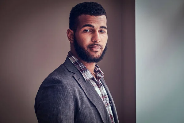 Joven afroamericano mirando una cámara en un estudio . — Foto de Stock